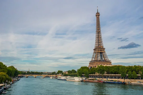 Torre Eiffel perto do rio Sena, símbolo de Paris e marco icônico na França, em um dia ensolarado brilhante. Lugares turísticos famosos e destinos de viagem românticos na Europa. Conceito de vida urbana e turismo — Fotografia de Stock