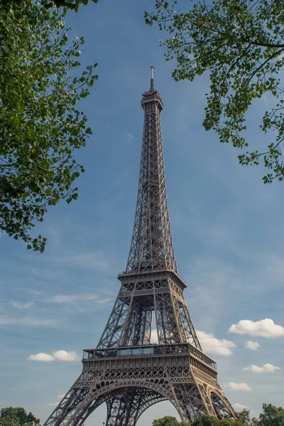 Torre Eiffel, simbolo di Parigi e punto di riferimento iconico in Francia, in una giornata di sole con nuvole nel cielo. Luoghi turistici famosi e mete turistiche romantiche in Europa. Vacanze e turismo concetto — Foto Stock