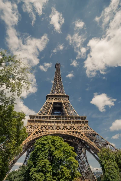 Torre Eiffel, símbolo de Paris e marco icônico na França, em um dia ensolarado com nuvens no céu. Lugares turísticos famosos e destinos de viagem românticos na Europa. Férias e conceito de turismo — Fotografia de Stock