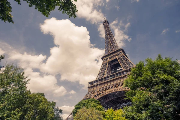 Eiffeltoren, Parijs symbool en iconische mijlpaal in Frankrijk, op een zonnige dag met wolken in de lucht. Bekende toeristische plaatsen en romantische reizen bestemmingen in Europa. Vakantie en toerisme concept — Stockfoto