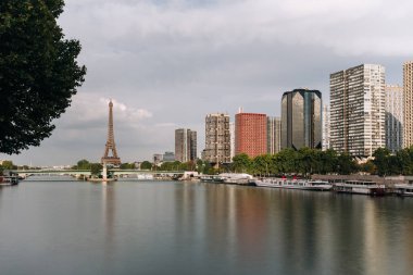 Eyfel Kulesi, ünlü Paris sembolü ve Fransa ve bulutlu bir günde Seine Nehri'ne yakın konut ikonik simgesel yapı. Avrupa, turizm ve şehir hayat kavramı içinde popüler seyahat hedef