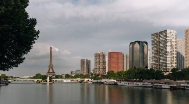 Eyfel Kulesi, ünlü Paris sembolü ve Fransa ve bulutlu bir günde Seine Nehri'ne yakın konut ikonik simgesel yapı. Avrupa, turizm ve şehir hayat kavramı içinde popüler seyahat hedef