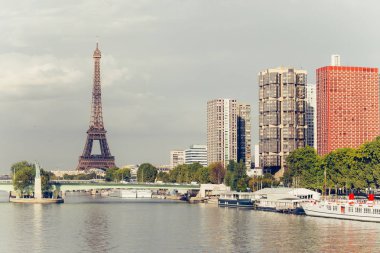 Eyfel Kulesi, ünlü Paris sembolü ve Fransa ve bulutlu bir günde Seine Nehri'ne yakın konut ikonik simgesel yapı. Avrupa, turizm ve şehir hayat kavramı içinde popüler seyahat hedef