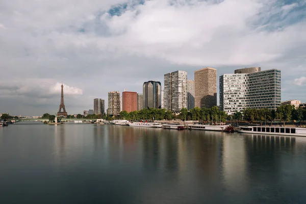 Tour Eiffel, célèbre symbole de Paris et emblématique monument en France et bâtiments résidentiels à proximité de la Seine par temps nuageux. Destination de voyage populaire en Europe, concept de tourisme et de vie urbaine — Photo