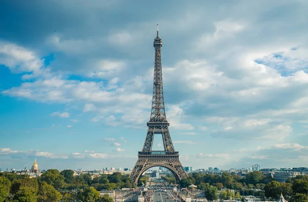 Torre Eiffel, símbolo de Paris e marco icônico na França, em um dia ensolarado com nuvens no céu. Lugares turísticos famosos e destinos de viagem românticos na Europa. Conceito de vida urbana e turismo — Fotografia de Stock