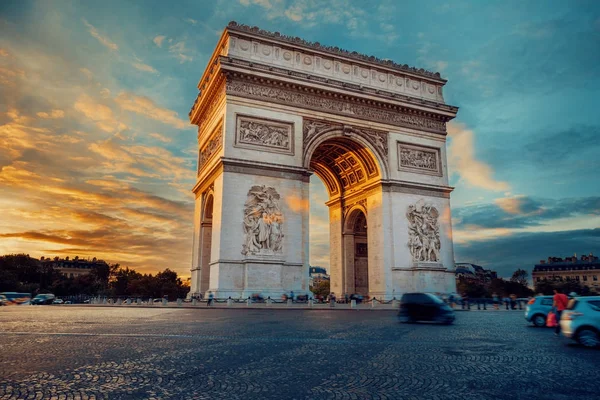 Ünlü Paris avenue Champs-Elysees ve zafer takı, parlak güneşli bulutlu gökyüzü ile zafer sembolü. İkonik turistik landmark ve romantik seyahat yerler Fransa. Uzun pozlama
