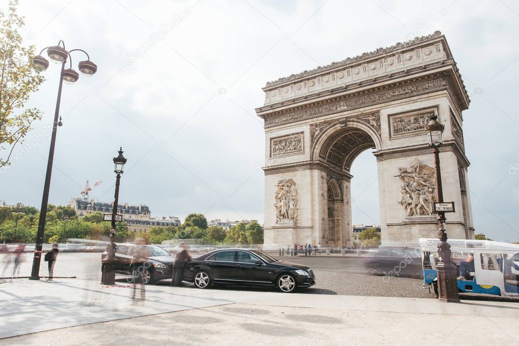 Famous Triumphal Arch, symbol of the glory and historical heritage. Iconic architectural landmark of Paris, France. Charles de Gaulle square. City life, tourism and travel concept. Long exposure.