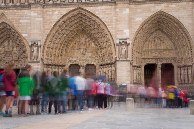 Notre-Dame de Paris, bulutlu bir günde ünlü antik Katolik Katedrali girişe yakın kişi. Fransa'nın turistik tarihi ve mimari landmark. Din, turizm ve seyahat kavramı.