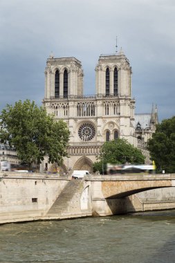 Notre-Dame de Paris, bulutlu bir günde Seine Nehri iskele üzerinde ünlü antik Katolik Katedrali. Fransa'nın turistik tarihi ve mimari landmark. Din, turizm ve seyahat kavramı.