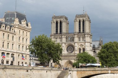 Notre-Dame de Paris, bulutlu bir günde Seine Nehri iskele üzerinde ünlü antik Katolik Katedrali. Fransa'nın turistik tarihi ve mimari landmark. Din, turizm ve seyahat kavramı.