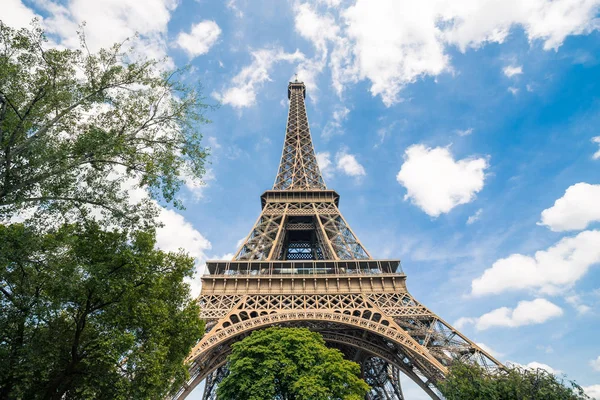 Torre Eiffel, símbolo de Paris e marco icônico na França, em um dia ensolarado com nuvens no céu. Lugares turísticos famosos e destinos de viagem românticos na Europa. Férias e conceito de turismo — Fotografia de Stock