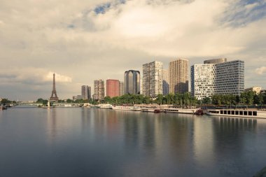 Eyfel Kulesi, ünlü Paris sembolü ve Fransa ve bulutlu bir günde Seine Nehri'ne yakın konut ikonik simgesel yapı. Avrupa, turizm ve şehir hayat kavramı içinde popüler seyahat hedef