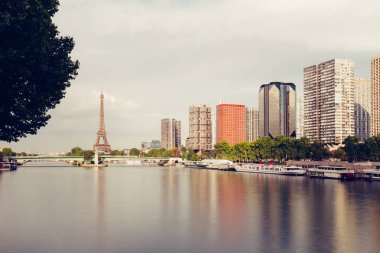 Eyfel Kulesi, ünlü Paris sembolü ve Fransa ve bulutlu bir günde Seine Nehri'ne yakın konut ikonik simgesel yapı. Avrupa, turizm ve şehir hayat kavramı içinde popüler seyahat hedef