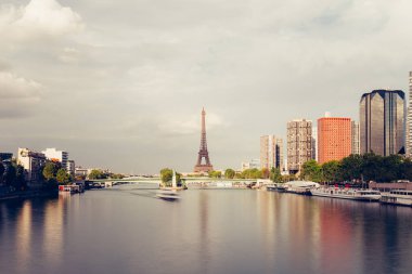 Eyfel Kulesi, ünlü Paris sembolü ve Fransa ve bulutlu bir günde Seine Nehri'ne yakın konut ikonik simgesel yapı. Avrupa, turizm ve şehir hayat kavramı içinde popüler seyahat hedef