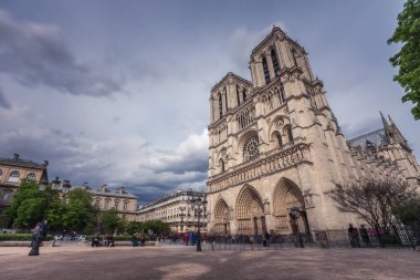 Notre-Dame de Paris, bulutlu bir günde Seine Nehri iskele üzerinde ünlü antik Katolik Katedrali. Fransa'nın turistik tarihi ve mimari landmark. Din, turizm ve seyahat kavramı.