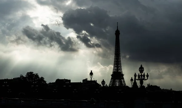 Eiffel toren silhouet, symbool van Parijs en iconische mijlpaal in Frankrijk op een bewolkte dag met dramatische hemel. Bekende toeristische plaatsen en romantische reizen bestemmingen in Europa. Toerisme concept — Stockfoto