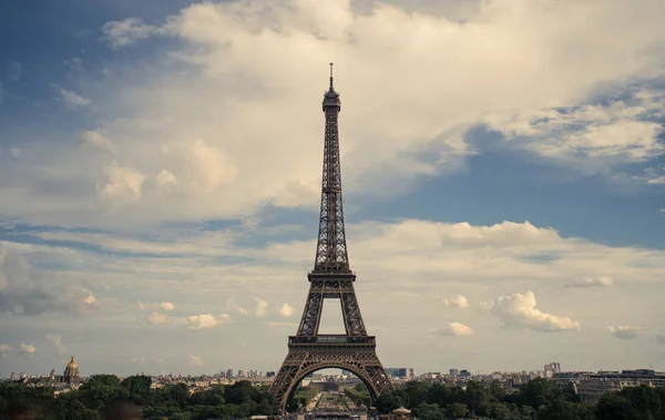 Torre Eiffel, simbolo di Parigi e punto di riferimento iconico in Francia, in una giornata di sole con nuvole nel cielo. Luoghi turistici famosi e mete turistiche romantiche in Europa. Concetto di vita cittadina e turismo — Foto Stock