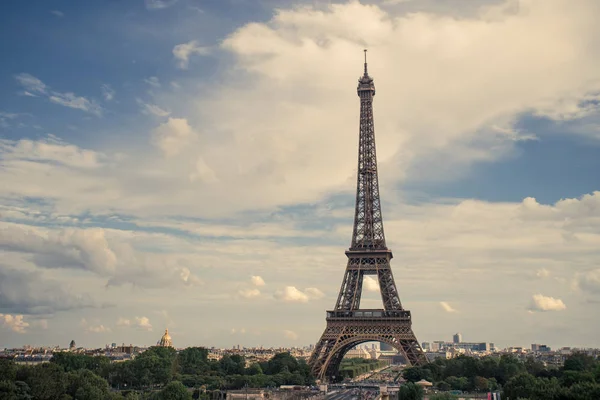 Torre Eiffel, símbolo de Paris e marco icônico na França, em um dia ensolarado com nuvens no céu. Lugares turísticos famosos e destinos de viagem românticos na Europa. Conceito de vida urbana e turismo — Fotografia de Stock