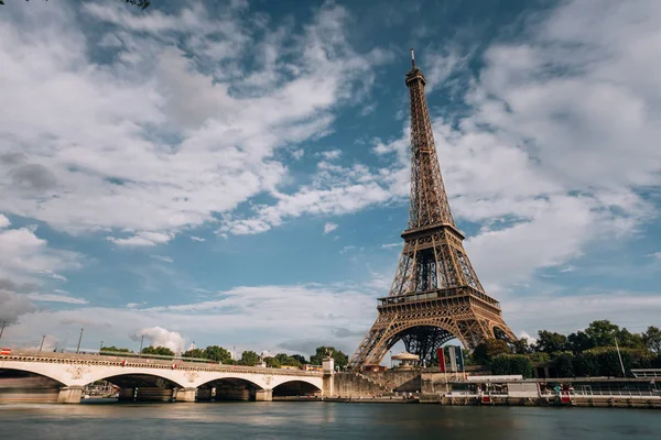 Torre Eiffel perto do rio Sena, símbolo de Paris e marco icônico na França, em um dia ensolarado brilhante. Lugares turísticos famosos e destinos de viagem românticos na Europa. Conceito de vida urbana e turismo — Fotografia de Stock