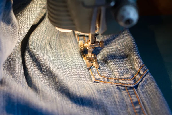 Naaien op de naaimachine jeans. — Stockfoto