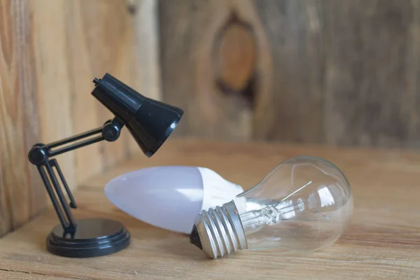 Small table lamp made of black plastic on a wooden background. — Stock Photo, Image