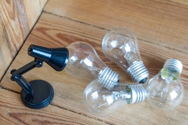 Small table lamp made of black plastic on a wooden background. — Stock Photo, Image