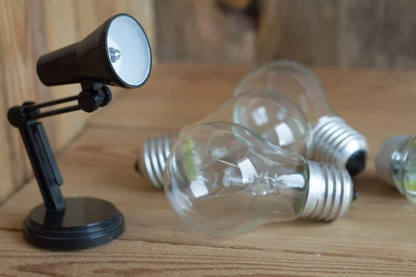 Piccola lampada da tavolo in plastica nera su sfondo di legno . — Foto Stock