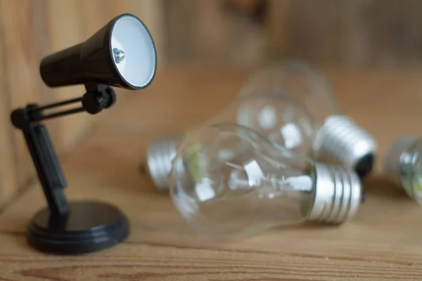 Piccola lampada da tavolo in plastica nera su sfondo di legno . — Foto Stock