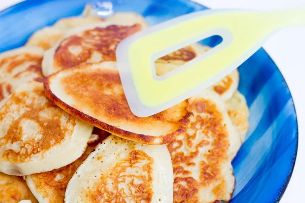 Beyaz zemin üzerinde mavi bir plaka üzerinde kırmızı taze pişmiş krep yalan.