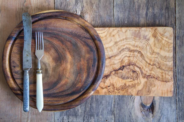 Stainless steel cutlery on a wooden chopping board — Stock Photo, Image