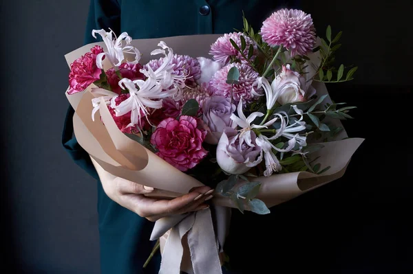 Weibliche Hände mit einem Blumenstrauß im Vintage-Stil auf dunklem Hintergrund, selektiver Fokus — Stockfoto