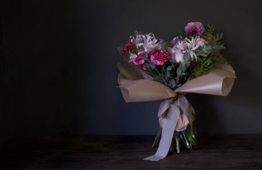 Koyu arkaplanlı, seçici odaklı, klasik tarzda dekore edilmiş buketin yakın çekimi