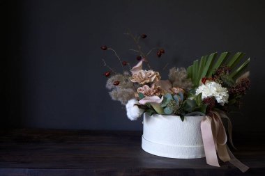 Eskimiş bir buketin olduğu bir kutu, koyu arkaplan, seçici odak