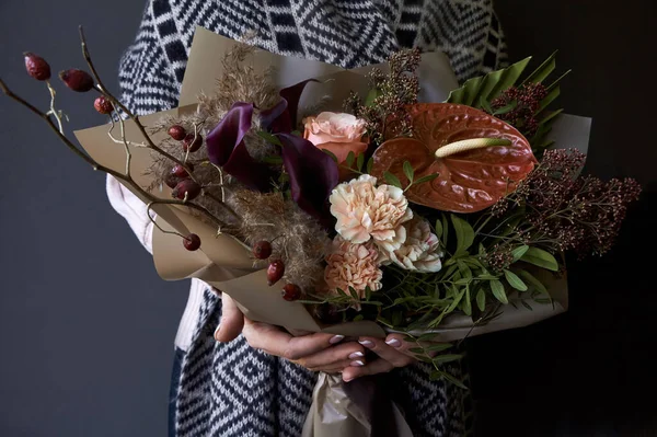 Weibliche Hände mit einem Blumenstrauß im Vintage-Stil auf dunklem Hintergrund, selektiver Fokus — Stockfoto