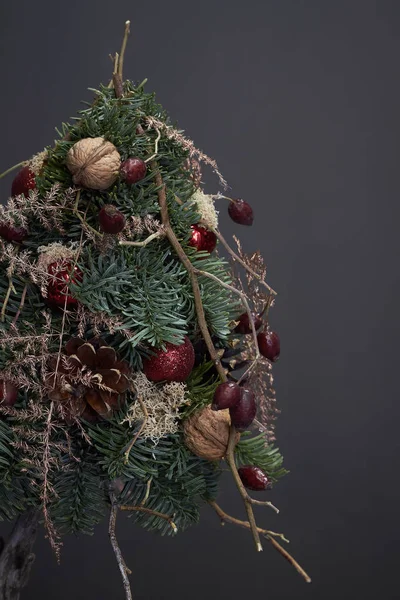 Composición de Navidad y Año Nuevo. Árbol de Navidad hecho de ramas de abeto y decorado con materiales naturales y bolas sobre fondo oscuro — Foto de Stock