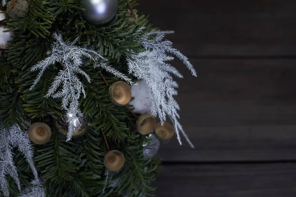 Composition de Noël et Nouvel An. Détail gros plan sapin de Noël fait de branches de sapin et décoré par des matériaux naturels et des boules sur fond sombre — Photo