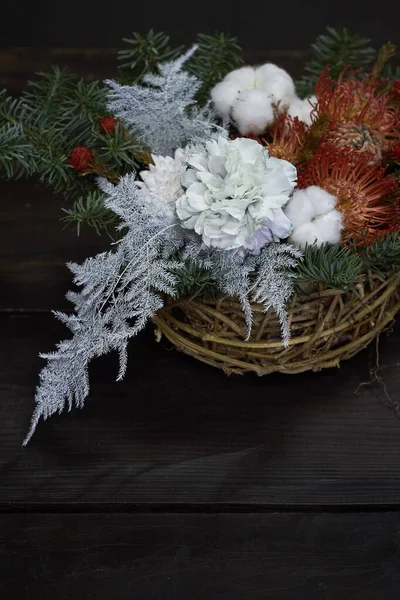 Composição de Natal e Ano Novo. Cesta de vime com ramos de abeto decorados por materiais naturais no fundo escuro — Fotografia de Stock