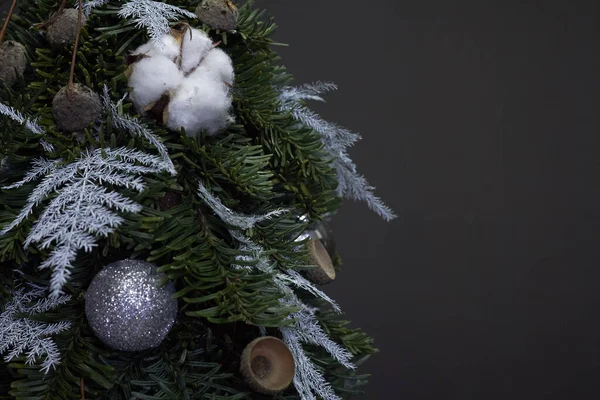 Jul- och nyårskomposition. Detalj närbild julgran gjord av gran grenar och dekorerad med naturliga material och bollar på mörk bakgrund — Stockfoto