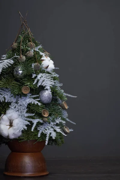 Natale e Capodanno composizione. Albero di Natale fatto di rami di abete e decorato con materiali naturali e palle in una pentola di argilla — Foto Stock
