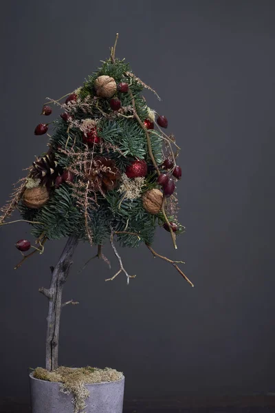 Composición de Navidad y Año Nuevo. Árbol de Navidad hecho de ramas de abeto y decorado con materiales naturales y bolas en una olla de cemento — Foto de Stock