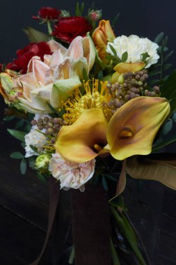 Koyu arkaplanda cam vazoda klasik tarzda çıplak bir buket, seçici bir odak.