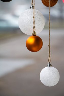 Yeni yıl ya da Noel arkaplanı, bulanık arkaplanda beyaz ve altın renkli Noel balolarının yakın çekimi, seçici odaklanma