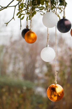 Yeni yıl ya da Noel arkaplanı, bulanık arkaplanda beyaz ve altın renkli Noel balolarının yakın çekimi, seçici odaklanma