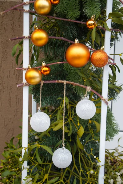 Capodanno o sfondo di Natale, primo piano di palline di Natale bianche e oro e vischio su uno sfondo sfocato, messa a fuoco selettiva — Foto Stock