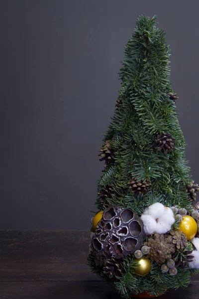 Christmas tree made of fir branches and decorated by natural materials and balls. Christmas and New Year minimalistic composition. — Stock Photo, Image