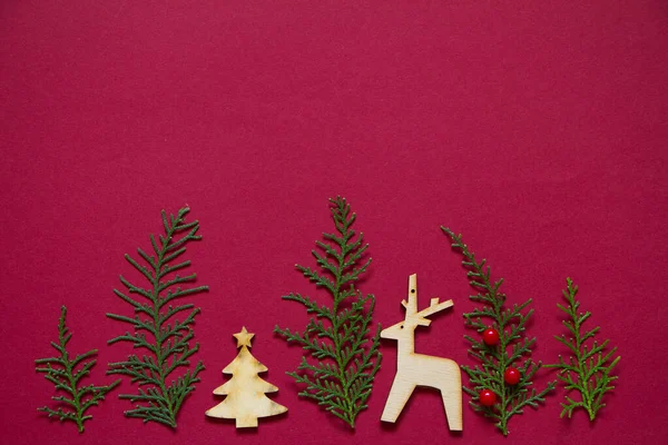 Träd form gjord av thuja grenar och trä figurer av julgran och rådjur. Minimal vinter kreativa bord platt låg — Stockfoto