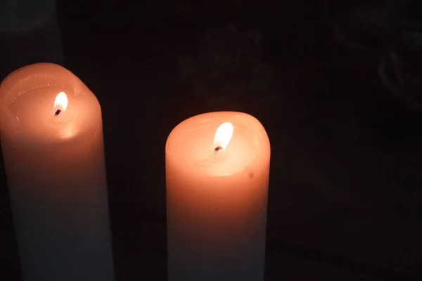 Gros plan de deux grandes bougies blanches qui brûlent dans l'obscurité, mise au point sélective — Photo