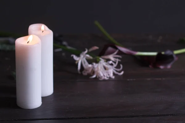 Primer plano de dos grandes velas blancas ardiendo sobre un fondo oscuro, enfoque selectivo — Foto de Stock