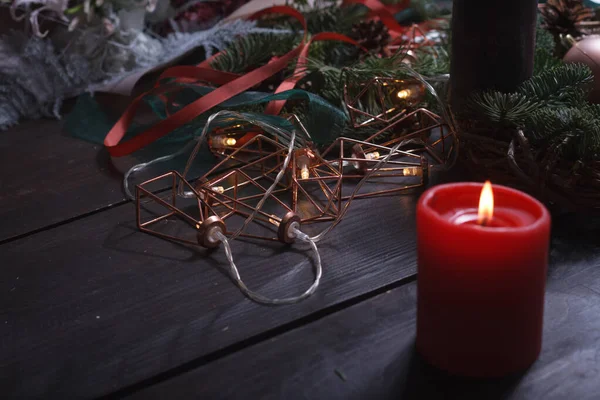 Close-up de um ambiente de trabalho acolhedor de um florista com velas acesas ao criar uma grinalda de Natal, foco seletivo — Fotografia de Stock