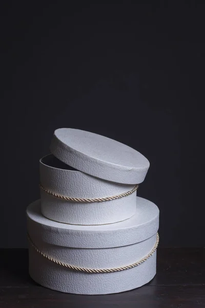 Κοντινό πλάνο δύο λευκά στρογγυλά κουτιά καπέλο δώρο σε σκούρο φόντο, επιλεκτική εστίαση — Φωτογραφία Αρχείου
